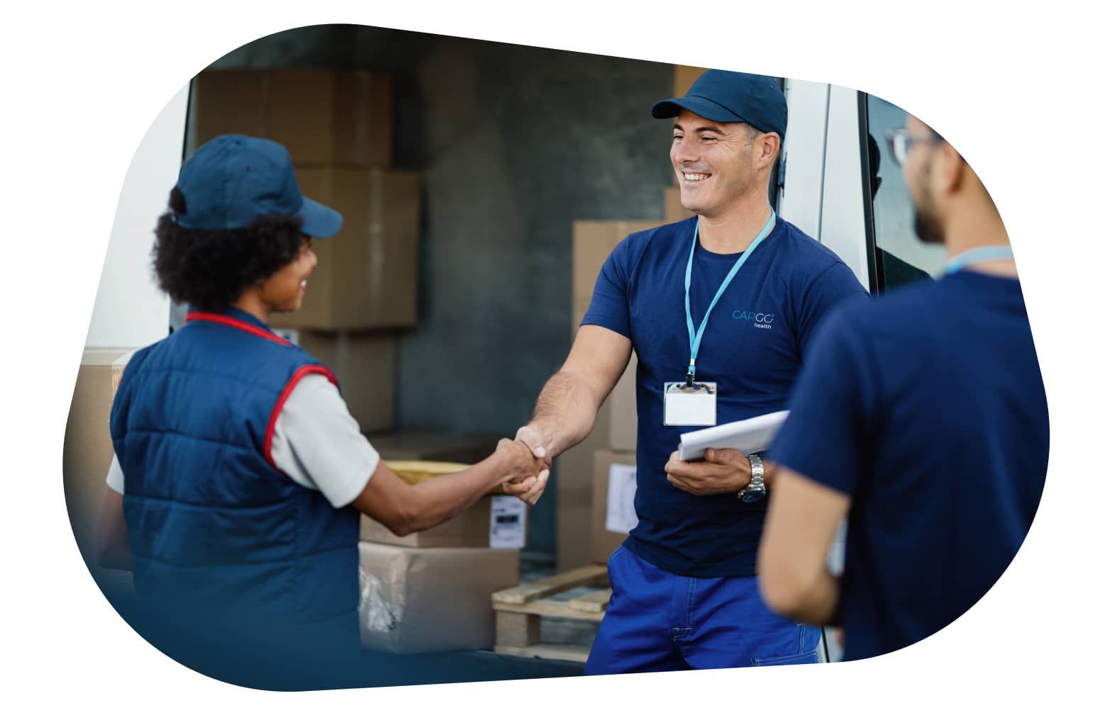 A smiling carGO Health medical courier, leaning on a stack of boxes in a delivery vehicle.