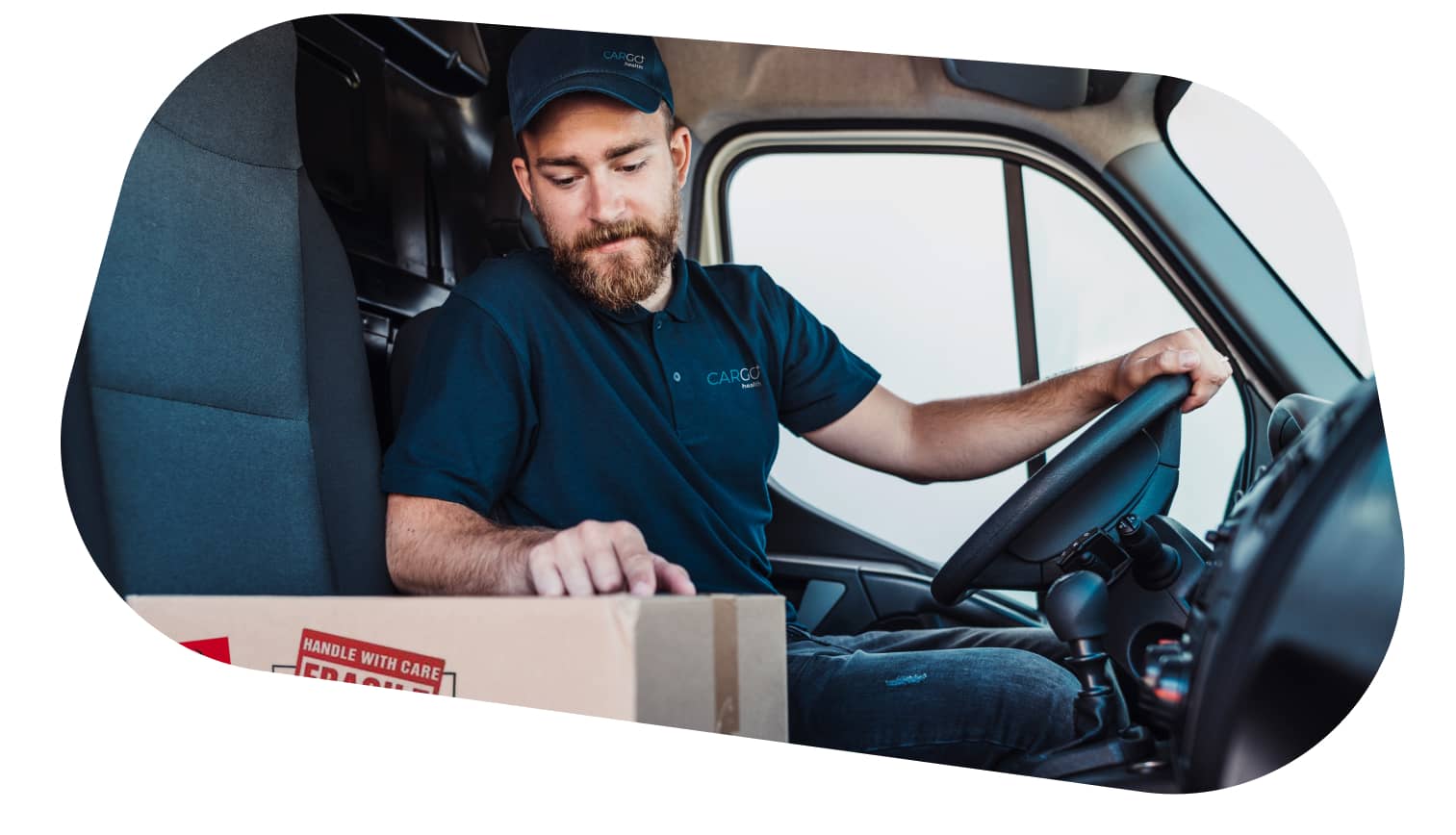 A carGO Health driver in a vehicle, reaching for a package placed next to him.